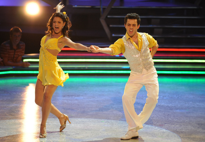 Man and Woman in Yellow and White Dance outfits disco dancing in front of crowd